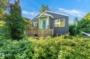 Dark gray siding with white trim, a light green entryway, a light blue door, and a wooden front deck - 10943 72 Avenue Nw, Edmonton, AB 