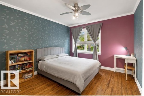 Wood-finish flooring, ceiling fan with integrated lighting, window with drapes, and crown molding - 10943 72 Avenue Nw, Edmonton, AB 
