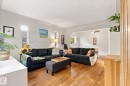Warm wood-finish flooring extends throughout, complemented by arched entryway details - 10943 72 Avenue Nw, Edmonton, AB 