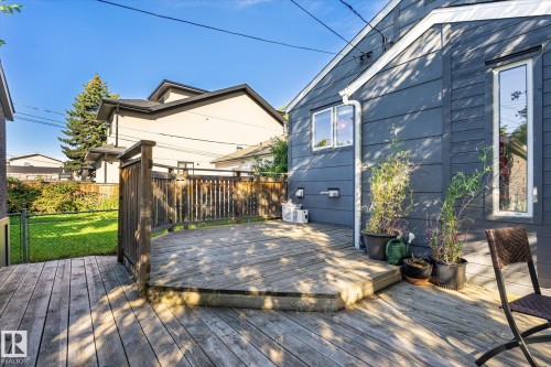 Hardwood deck with a partial railing, leading to a lawn area with perimeter fencing - 10943 72 Avenue Nw, Edmonton, AB 