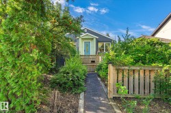 Home exterior featuring a light blue entry door, an exterior light fixture, and multiple windows - 