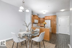 Kitchen with wood cabinetry, light countertops, and white appliances - 