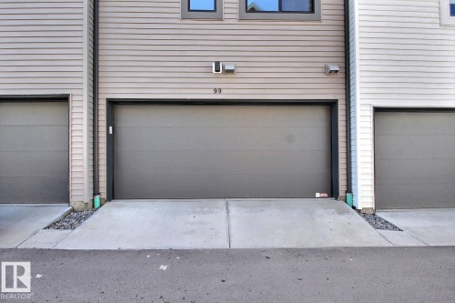 Attached single-car garage featuring a grey overhead door - #99 1010 Rabbit Hill Rd Sw, Edmonton, AB 