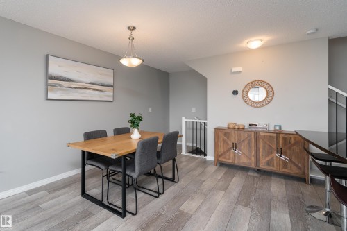 Wood-finish flooring throughout, with a built-in wood-look side cabinet - 20247 16 Avenue Nw, Edmonton, AB 