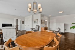 Hardwood-finish flooring, recessed lighting, and a modern chandelier illuminate this open space - 