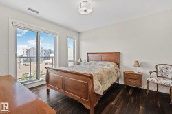 Hardwood flooring, sliding glass door with balcony access, additional window, ceiling-mounted light fixture, and light wall finishes - 