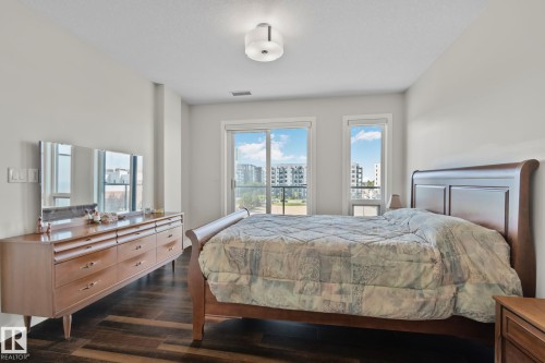 Dark wood-finish flooring with light wall tones - #404 2755 109 St Nw, Edmonton, AB 