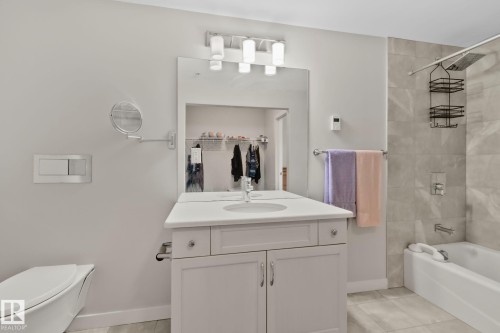 White shaker-style vanity with a single basin sink, light-toned countertop, and chrome hardware - #404 2755 109 St Nw, Edmonton, AB 
