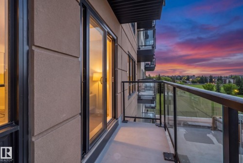 Balcony featuring black metal and glass railings, and a concrete-finish floor - #404 2755 109 St Nw, Edmonton, AB 