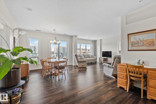 Open-concept living space featuring wood-finish flooring, recessed lighting, and multiple windows - #404 2755 109 St Nw, Edmonton, AB 