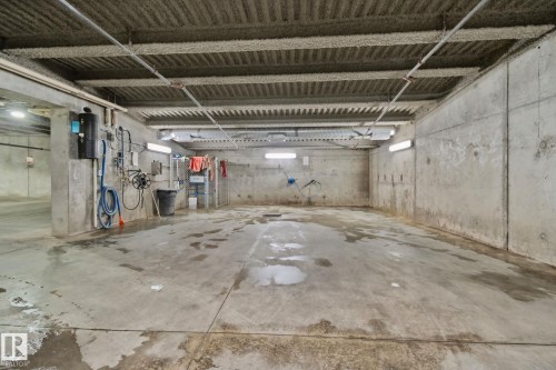 Concrete flooring with drainage, exposed concrete walls, and overhead lighting - #404 2755 109 St Nw, Edmonton, AB 