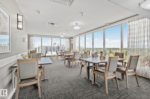 Expansive room with floor-to-ceiling windows, recessed lighting, and patterned carpeting - #404 2755 109 St Nw, Edmonton, AB 