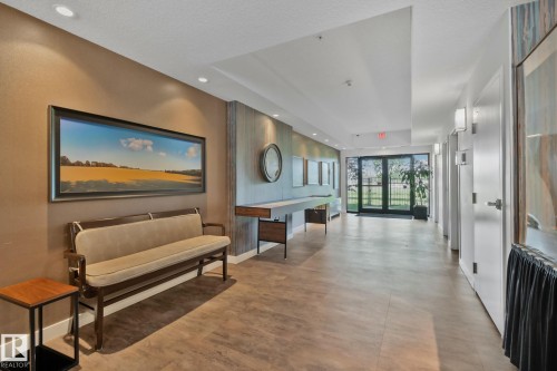 Recessed ceiling lighting, wood-finish flooring, accent wall paneling, full-light glass entry doors, and wall sconces - #404 2755 109 St Nw, Edmonton, AB 