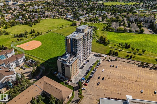 High-rise building with multiple balconies, situated adjacent to expansive green spaces and a baseball diamond - #404 2755 109 St Nw, Edmonton, AB 