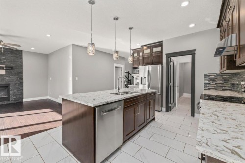 Kitchen island featuring a dual basin sink and integrated dishwasher - 1090 Armitage Crescent Sw, Edmonton, AB 