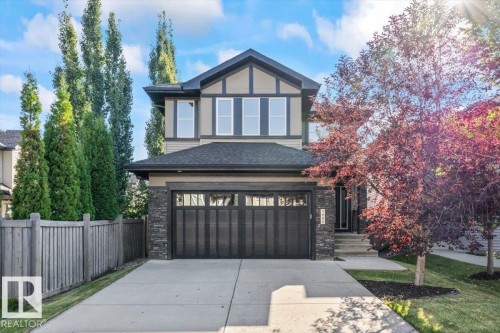 Contemporary two-story home featuring a striking black and white Tudor-inspired exterior with vertical siding accents - 1090 Armitage Crescent Sw, Edmonton, AB 
