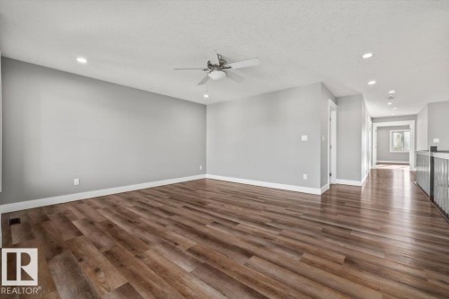 Spacious room with wood-finish flooring, recessed lighting, and a ceiling fan - 1090 Armitage Crescent Sw, Edmonton, AB 