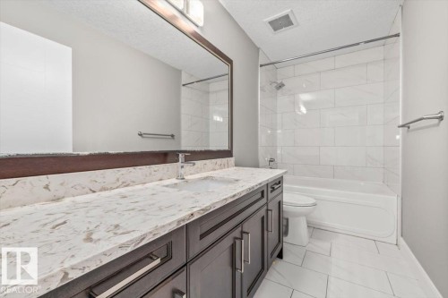 Extended vanity with light-toned countertop, dark wood-finish cabinetry, and chrome hardware - 1090 Armitage Crescent Sw, Edmonton, AB 