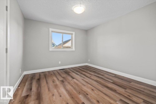 Light gray walls with wood-finish flooring - 1090 Armitage Crescent Sw, Edmonton, AB 