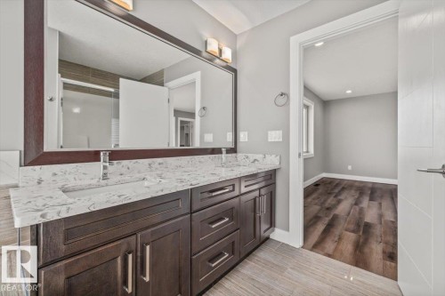 Dual sink vanity with a white countertop and dark wood-finish cabinetry - 1090 Armitage Crescent Sw, Edmonton, AB 