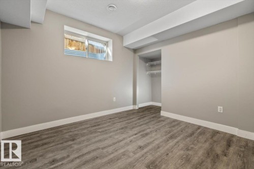 Recessed lighting, wood-finish flooring, white trim, and a built-in closet with wire shelving - 1090 Armitage Crescent Sw, Edmonton, AB 