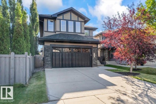 Contemporary two-story exterior with a two-car attached garage, stone accents, and a concrete driveway - 1090 Armitage Crescent Sw, Edmonton, AB 
