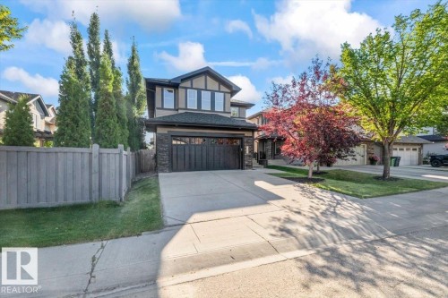 Two-story exterior featuring a stone and siding facade, an integrated two-car garage, and a concrete driveway - 1090 Armitage Crescent Sw, Edmonton, AB 