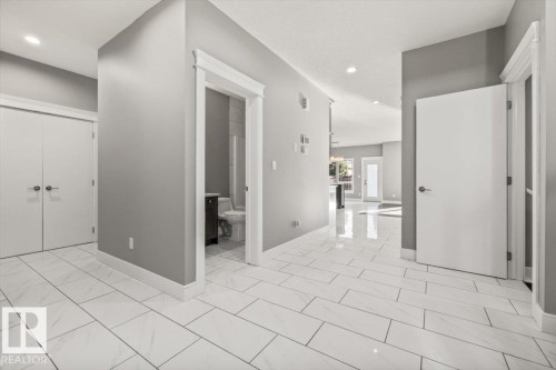 White rectangular tile flooring, recessed lighting, white doors, and a neutral wall color - 1090 Armitage Crescent Sw, Edmonton, AB 
