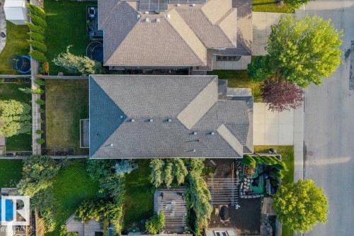 Gabled roofline with shingle detailing, concrete driveway, and established landscaping - 1090 Armitage Crescent Sw, Edmonton, AB 