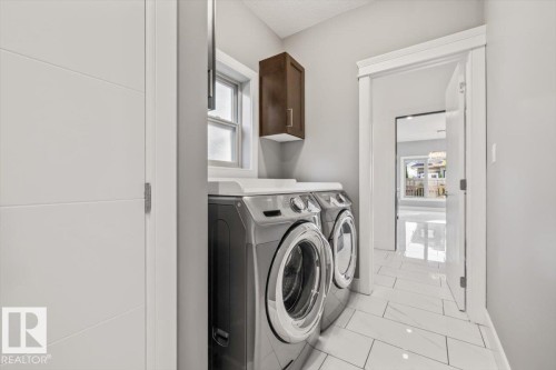 Laundry area featuring a window, built-in cabinetry, and tile flooring - 1090 Armitage Crescent Sw, Edmonton, AB 