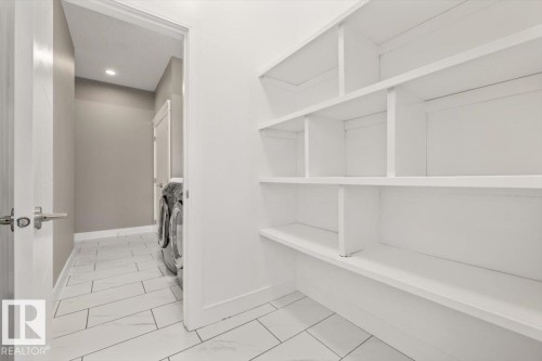 Laundry area with built-in shelving, recessed lighting, and tile flooring - 1090 Armitage Crescent Sw, Edmonton, AB 