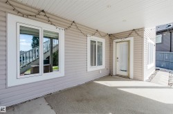 Covered patio area with concrete surfacing, multiple windows, and a glass-paneled door - 
