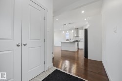 Hardwood flooring throughout, recessed lighting, white shaker cabinetry, kitchen island with pendant lighting, and stainless steel appliances - 