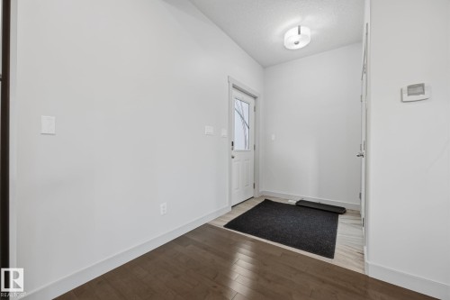 Wood-finish flooring, white trim, white walls, and a contemporary ceiling light fixture - 8952 81 Avenue Nw, Edmonton, AB 