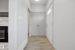 Foyer featuring light-colored tile flooring, white interior doors, and recessed lighting - 