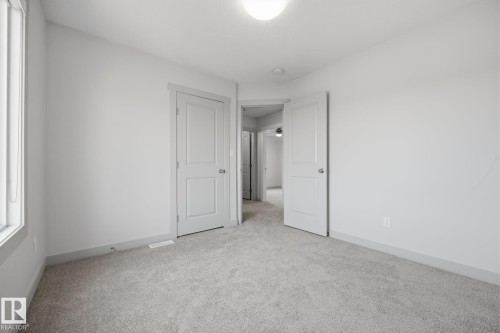 Neutral wall tones, light-toned carpeting, and a flush mount ceiling light fixture - 8952 81 Avenue Nw, Edmonton, AB 
