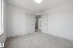 Neutral wall tones, light-toned carpeting, and a flush mount ceiling light fixture - 