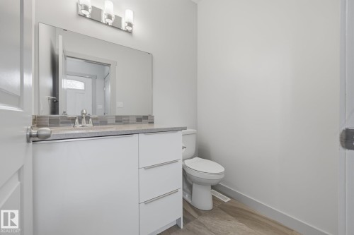Vanity with a light-toned countertop, under-mount sink, and mosaic tile backsplash - 8952 81 Avenue Nw, Edmonton, AB 