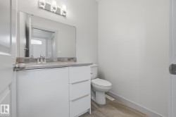 Vanity with a light-toned countertop, under-mount sink, and mosaic tile backsplash - 