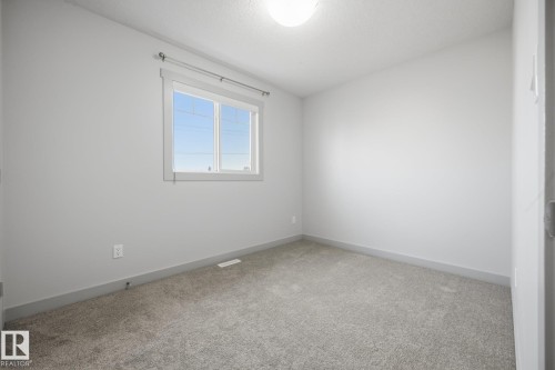 Carpeted room with a single window and a flush-mount ceiling light fixture - 8952 81 Avenue Nw, Edmonton, AB 