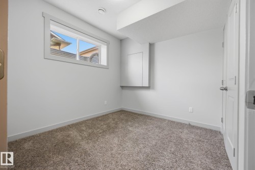 Carpeted flooring, neutral wall color, window with trim, white interior door, recessed ceiling light - 8952 81 Avenue Nw, Edmonton, AB 
