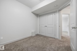 Plush carpet flooring, white painted walls, and paneled bifold closet doors with silver hardware - 