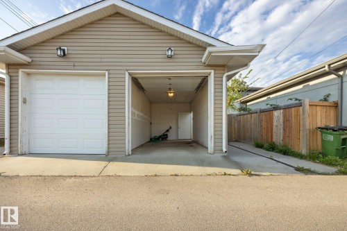 Two-car garage with white panel doors and light beige siding - 8952 81 Avenue Nw, Edmonton, AB 