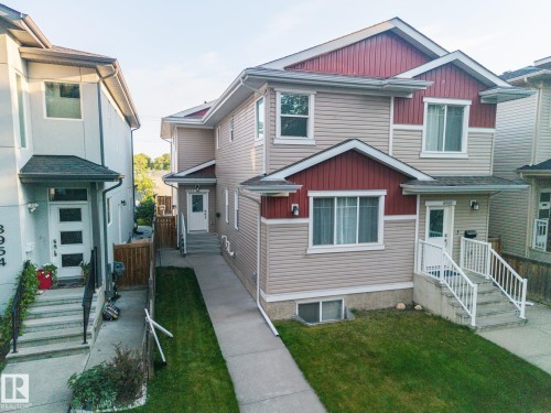 Two-story exterior with light-colored siding and a red accent gable - 8952 81 Avenue Nw, Edmonton, AB 