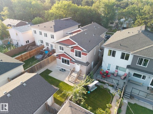 Multi-story residence featuring a two-tone exterior, dark shingle roof, and multiple windows - 8952 81 Avenue Nw, Edmonton, AB 