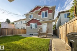 Two-story exterior with beige siding and red accents, featuring a front entry deck and walkway - 