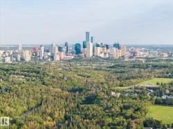 Urban skyline featuring high-rise buildings and surrounding green space with mature trees - 