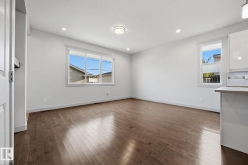 Recessed lighting, wood-finish flooring, white trim, and a window with a multi-pane design - 8952 81 Avenue Nw, Edmonton, AB 