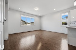 Recessed lighting, wood-finish flooring, white trim, and a window with a multi-pane design - 