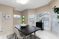 Recessed ceiling lighting, large bay window, light-toned flooring, contemporary chandelier, and a vibrant green door - 